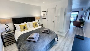 Un dormitorio moderno con una cama grande, lámparas de noche, un armario y vistas al exterior.