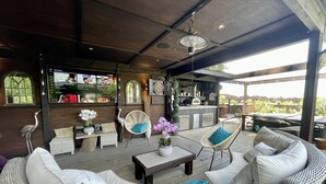 Un área de patio al aire libre con mobiliario de mimbre, un bar y vistas del exterior.