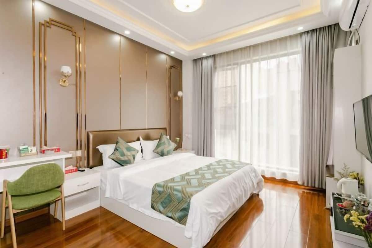 Une chambre d’hôtel moderne, dotée d’un grand lit, d’un bureau et d’une chaise.