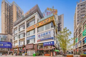 Un immeuble commercial à plusieurs étages, doté de nombreuses vitrines et enseignes.