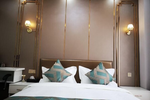 A hotel room with a bed, bedside tables, and wall-mounted lamps. - Kaibin Four Seasons Hotel (Renshou)