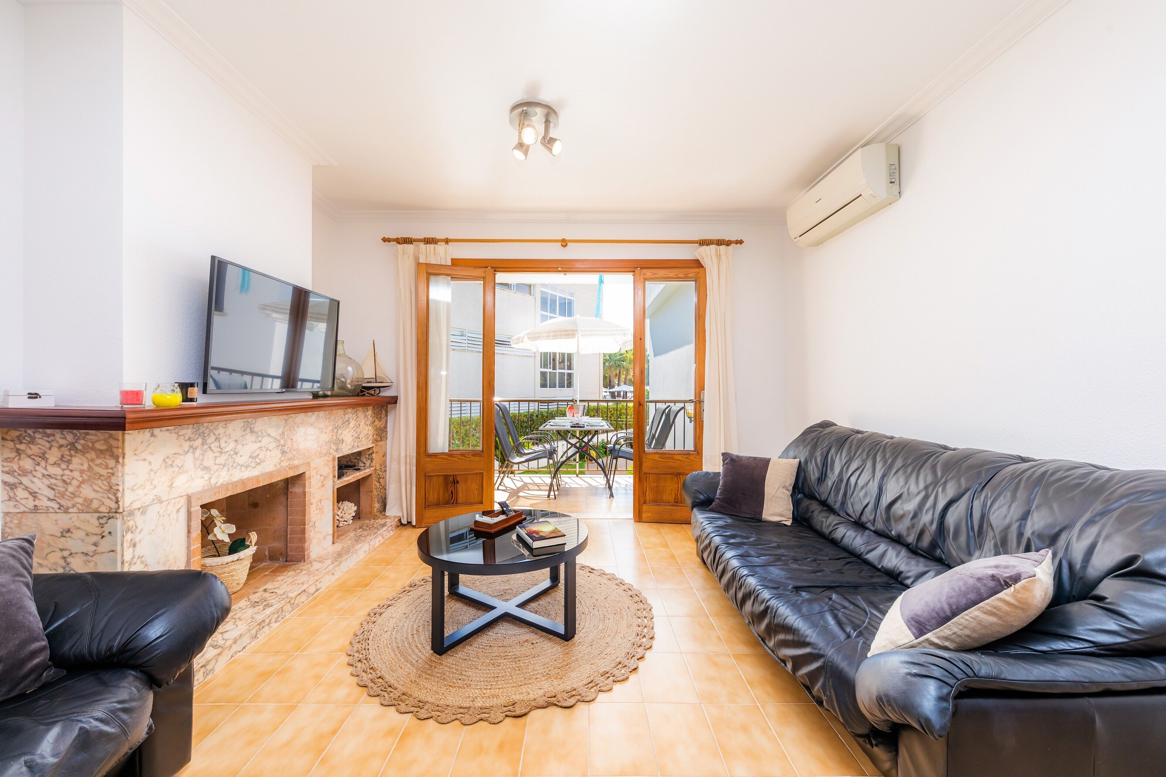 Una sala de estar con chimenea, televisor, sofá y comedor con mesa y sillas.