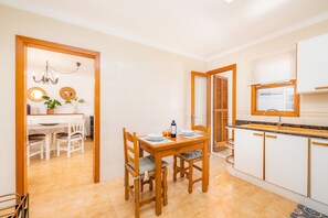 Una cocina moderna con comedor, muebles de madera y una araña.