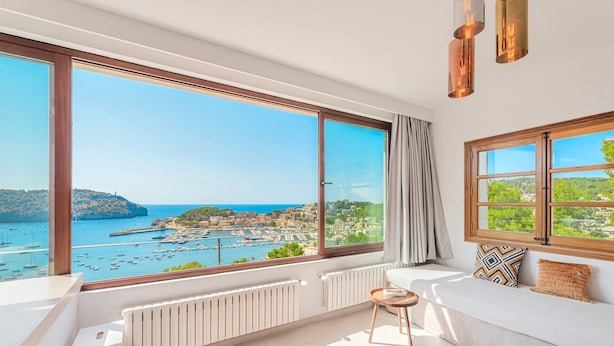 Et værelse med et stort karnapvindue, en hvid sofa, et lille bord og en radiator.