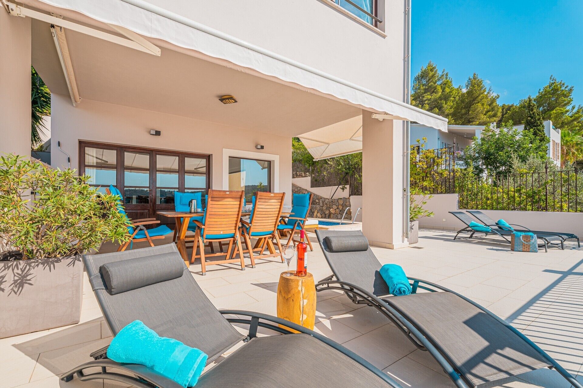 Un espace extérieur abrité comprenant des chaises longues, une table et une piscine.