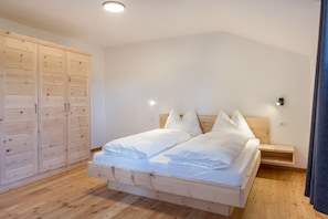 Une chambre à coucher avec un lit en bois, une armoire et une table de chevet.