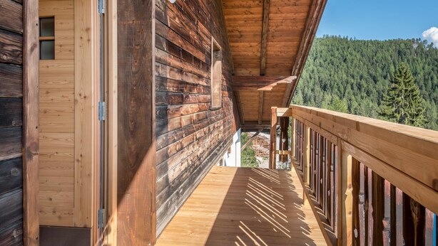 A wooden cabin with a balcony overlooking a forested area. - Holiday Apartment 'Nigglhof Katarina' with Mountain View, Balcony & Wi-Fi (redagno)
