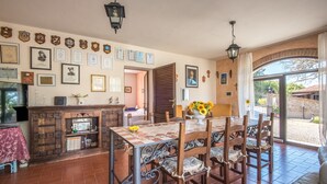 A dining area with a table and chairs, a fireplace, and a wall decorated with certificates and framed pictures. - 'Casa Vacanze Chianti Summer' with Pool, Garden & Wi-Fi (Gaiole in Chianti)