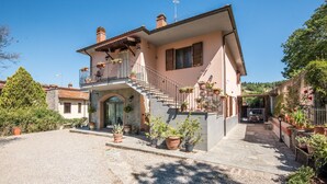 A two-story house with a balcony, a stone staircase, and potted plants. - 'Casa Vacanze Chianti Summer' with Pool, Garden & Wi-Fi (Gaiole in Chianti)