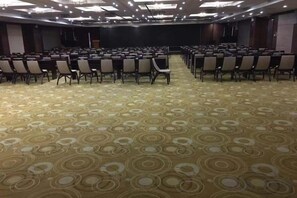 A conference room with rows of chairs and a carpeted floor. - Hailian Xianggan Hotel (Yongxin)