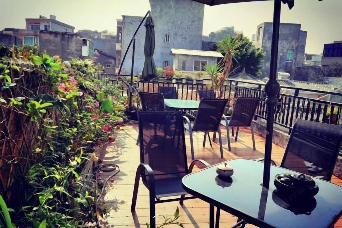 Una terraza en la azotea con mobiliario exterior, una mesa y vistas de los edificios circundantes.