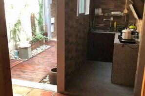 Uma cozinha estreita com bancada e janela.