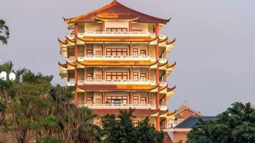 A multi-story building with a traditional architectural style, featuring multiple balconies and a tiered roof design.
