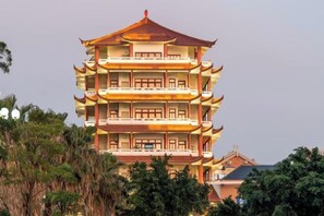 Um edifício de vários andares com arquitetura tradicional, com diversas varandas e um design de telhado em níveis.
