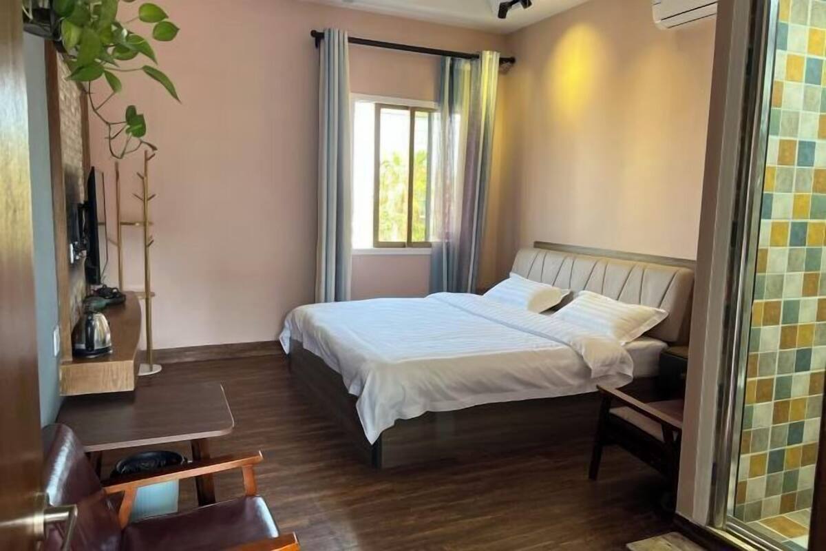 Un dormitorio con cama, escritorio y silla.