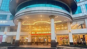 A modern building with a curved entrance and multiple floors. - Vienna International Hotel · Yonghe Branch, Wuli Industrial Zone, Quanzhou South Railway Station (Jinjiang)