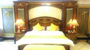 A large bed with a headboard, two bedside tables with lamps, and a bench at the foot of the bed. - Vienna International Hotel · Yonghe Branch, Wuli Industrial Zone, Quanzhou South Railway Station (Jinjiang)