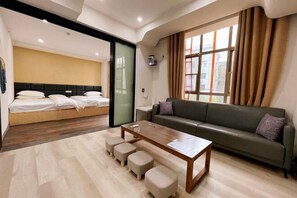 Ein modernes Wohnzimmer mit einer Couch, einem Couchtisch und einem Bett mit Kopfteil.
