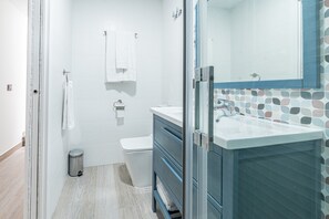 A bathroom with a shower, toilet, and sink.