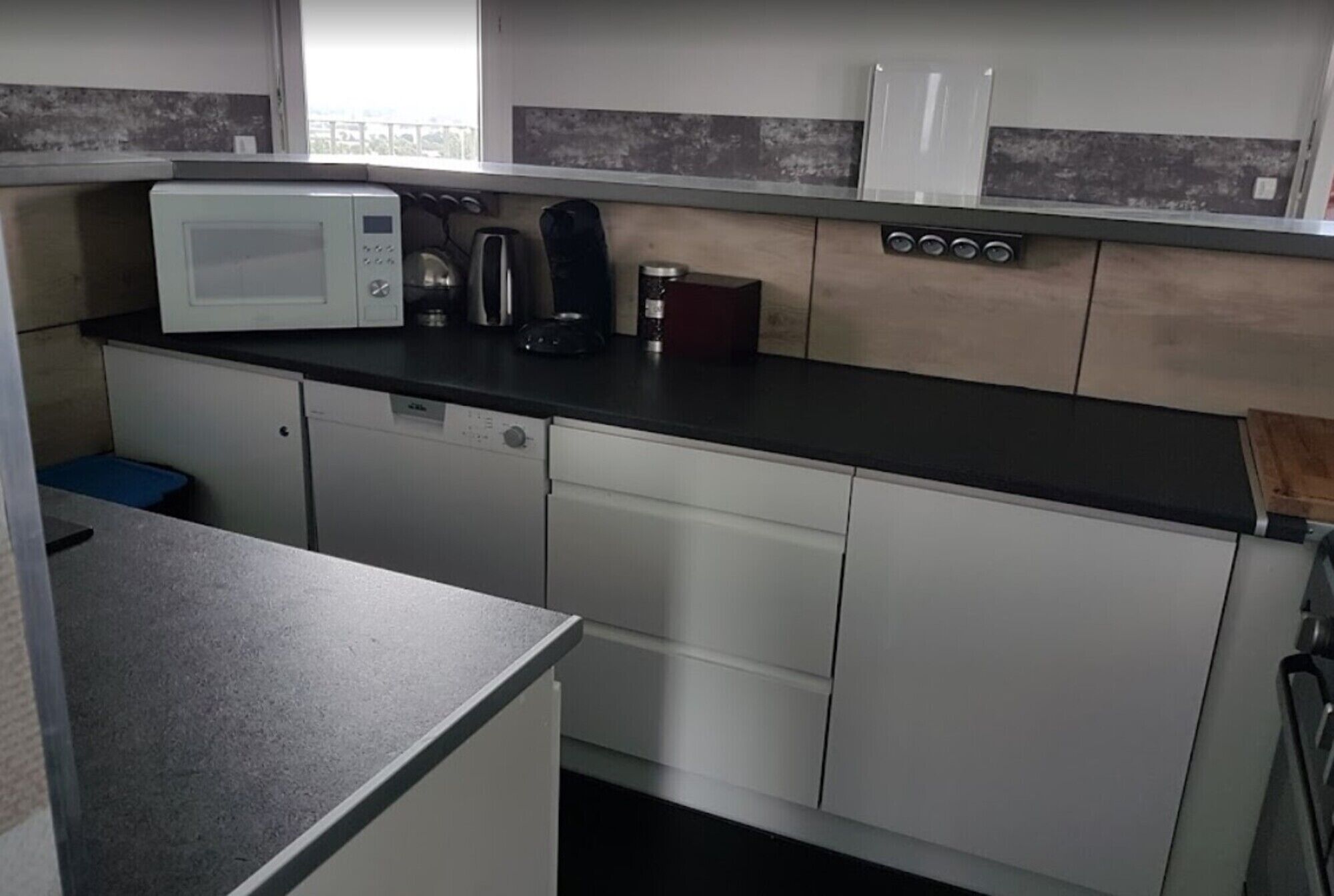 A compact kitchen with a microwave, coffee maker, and a small refrigerator.