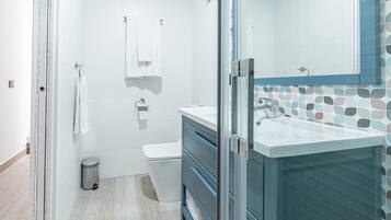 Ein Badezimmer mit Dusche, Toilette und Waschbecken.
