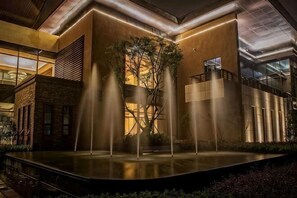 A modern building with a central fountain, a staircase, and a glass railing overlooking the area. - Golf Hotel Wuhan Yishan (Wuhan)