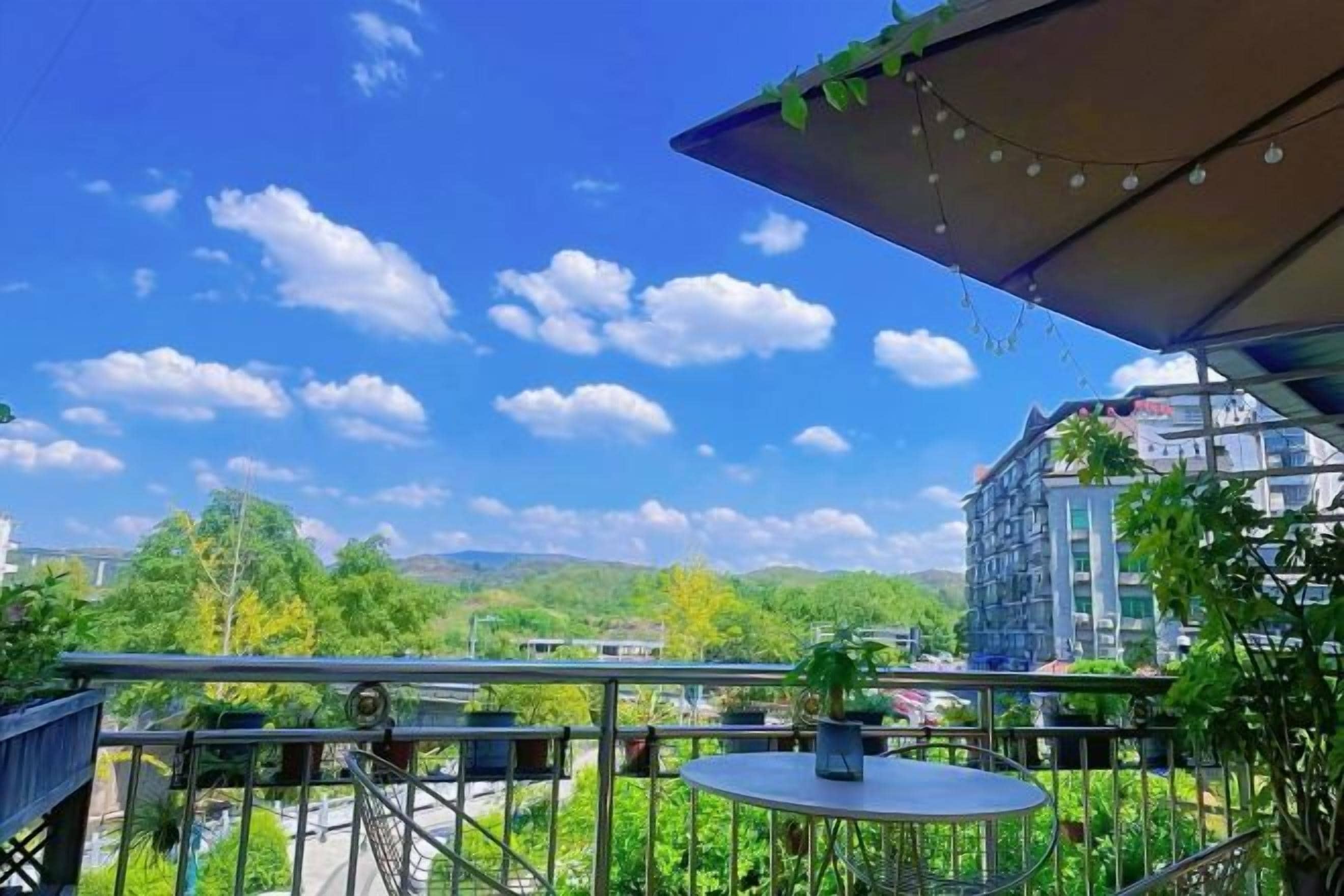 A balcony with a view of a cityscape and mountains.