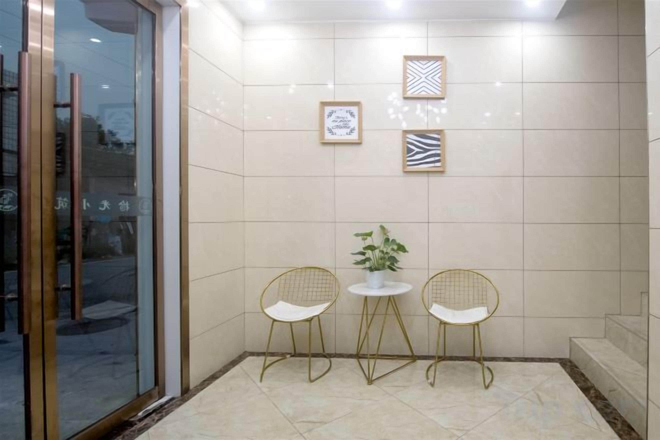 Petita habitació tancada amb dues cadires, un taulell, una planta en test i quadres penjats a la paret.