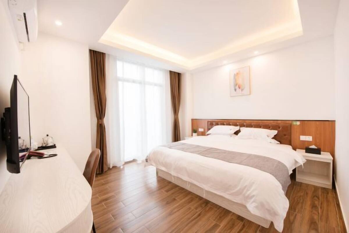 Ein Hotelzimmer mit einem großen Bett, einem Schreibtisch und einem Fernseher.