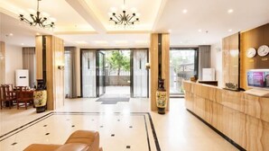 A hotel lobby with a reception desk, seating area, and a chandelier. - Xiaoshu Wushe Boutique Hostel (Haikou)