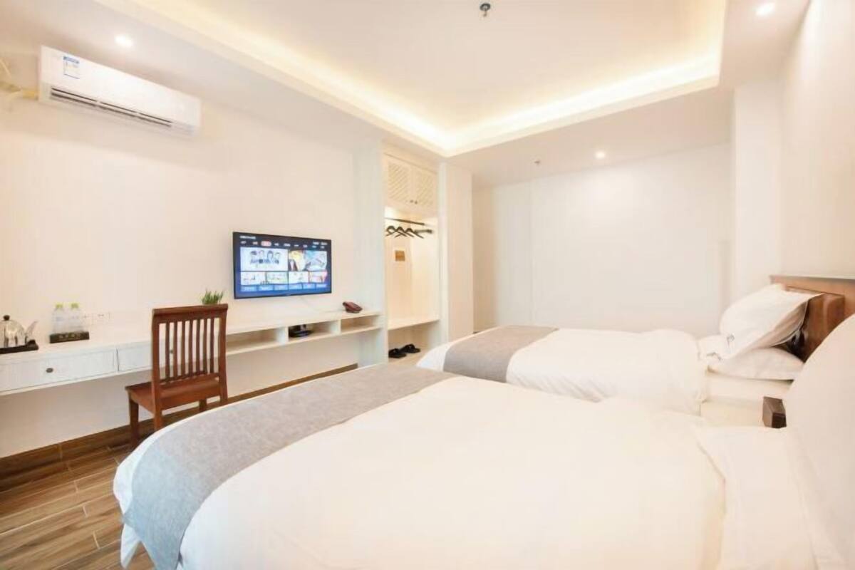 Ein Hotelzimmer mit einem Bett, einem Fernseher, einem Schreibtisch und einem Sessel.