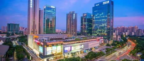 A modern urban skyline with high-rise buildings and a prominent shopping center.