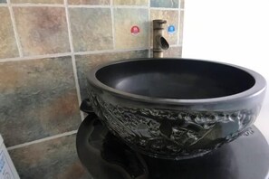 A bathroom with a black ceramic sink, a faucet, and a tiled wall. - Fushun ala warm hotel (Fushun)