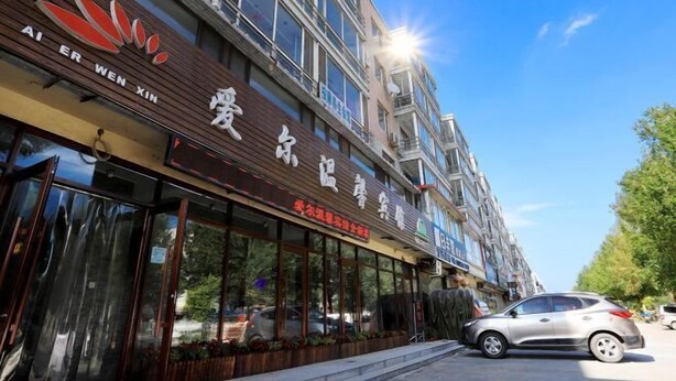 Ein Gebäude mit Restaurant im Erdgeschoss, ausgestattet mit großen Fenstern und einem Schild mit chinesischen Schriftzeichen.