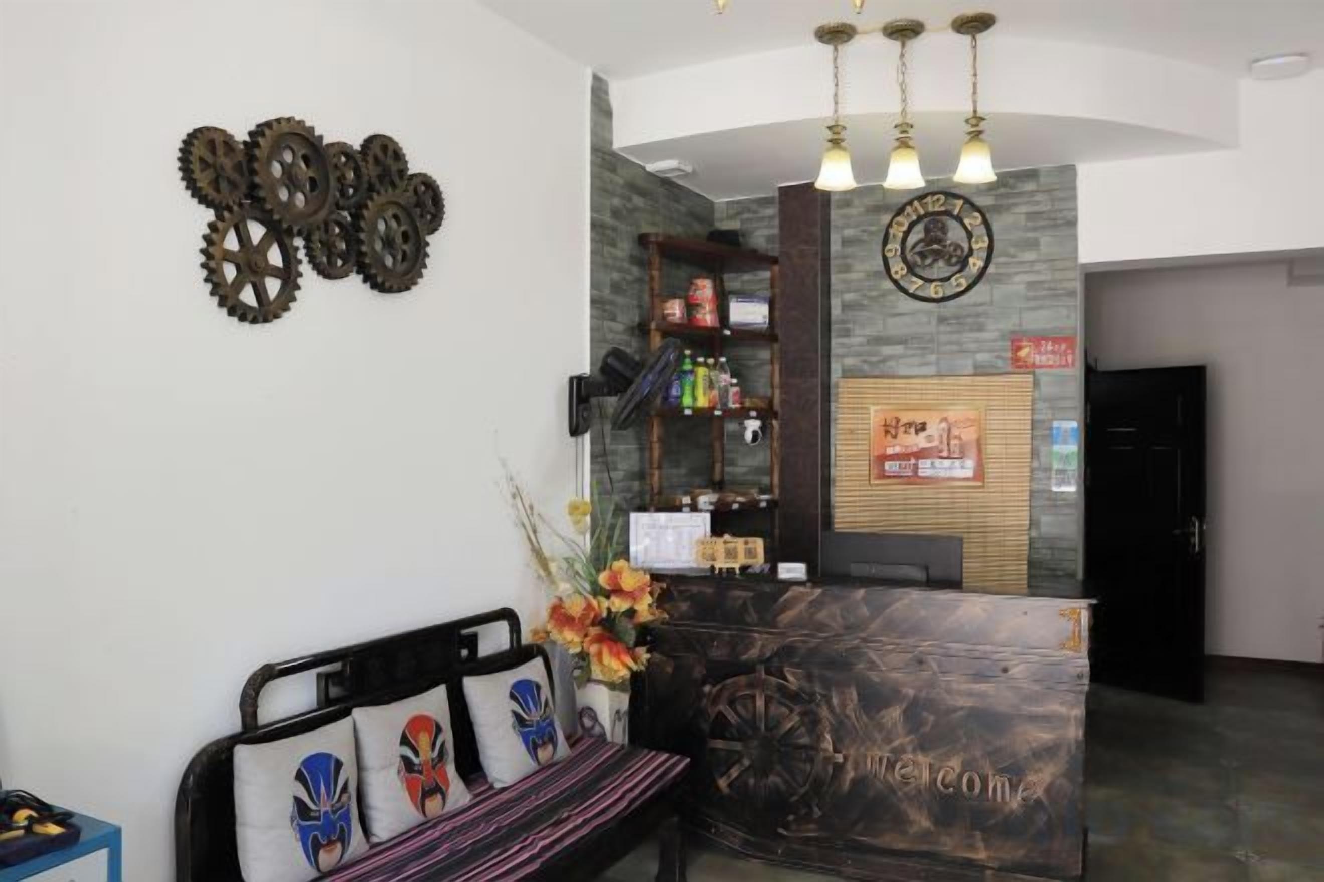 Un área de recepción con un mostrador de madera, un banco con cojines decorativos y un reloj montado en la pared.