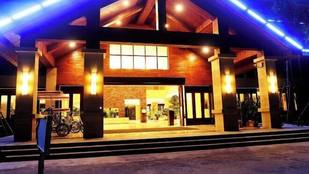 A building with a wooden facade, large windows, and a covered entrance area. - Yabulun Health & Wellness Holiday Hotel (Sanya)
