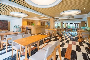 A modern dining area with wooden tables and chairs, a checkered floor, and a central counter.