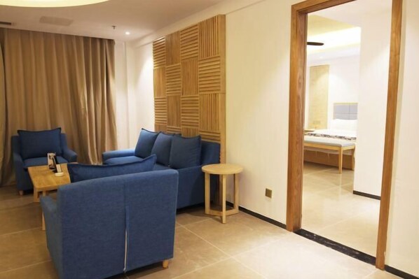 Een moderne hotelkamer met een modulaire bank, een klein rond tafeltje en een houten accentmuur.