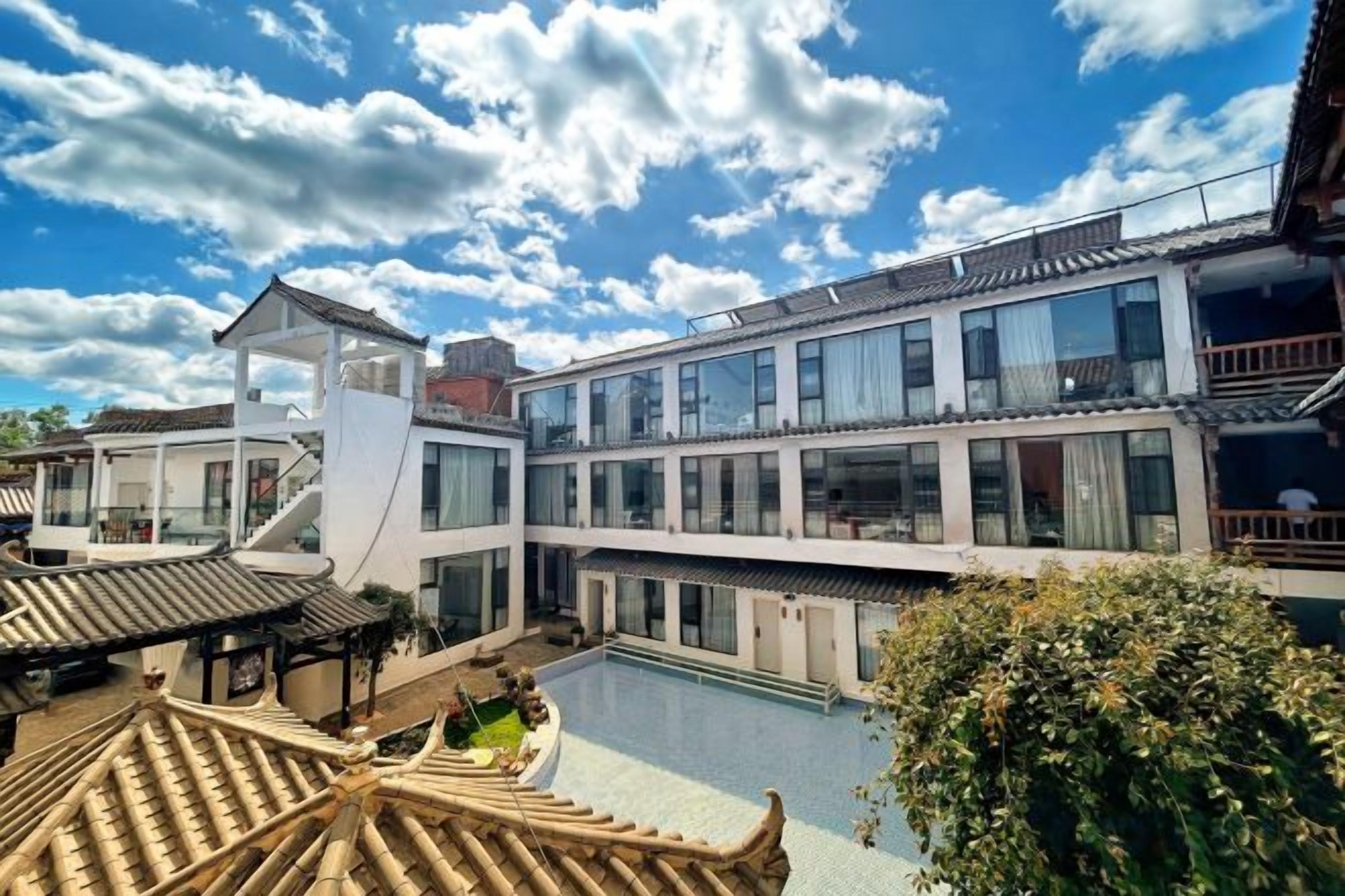 Um hotel moderno com piscina, arquitetura tradicional e área externa coberta.
