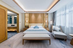 Een moderne hotelkamer met een groot bed, een zithoek en uitzicht op de stad.