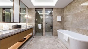 Een moderne badkamer met een grote spiegel, een badkuip en een douchehoek.