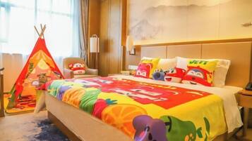 Habitación de hotel con cama, una silla, una mesita, ventana con cortinas y una lámpara de pared.