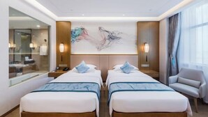 Een hotelkamer met twee bedden, een grote spiegel, een schilderij aan de muur en een stoel.