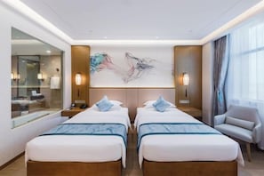 Une chambre d’hôtel avec deux lits, un grand miroir, un tableau au mur et une chaise.