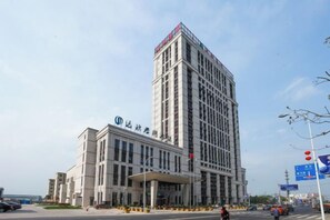 A multi-story hotel with a prominent entrance and a large sign above the main entrance. - Daxinjunlan Hotel (Hai'an)