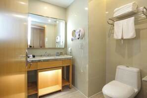 A modern bathroom with a vanity, a toilet, a towel rack, and a hairdryer.