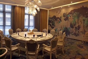A conference room with a round table, chairs, and a chandelier. - Daxinjunlan Hotel (Hai'an)