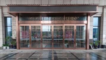 Entrada de un edificio con puerta de cristal y estructura metálica.