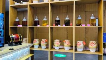 A wooden shelf with jars and a cylindrical container, likely a tea or spice display.