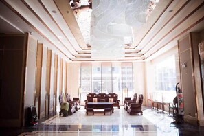 A spacious lobby with a high ceiling, large windows, and a central seating area. - Xiangdu Hotel (Jinxi)